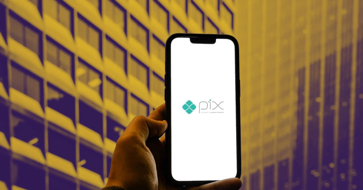 Pessoa segurando um smartphone exibindo o logotipo do PIX, pagamento por aproximação