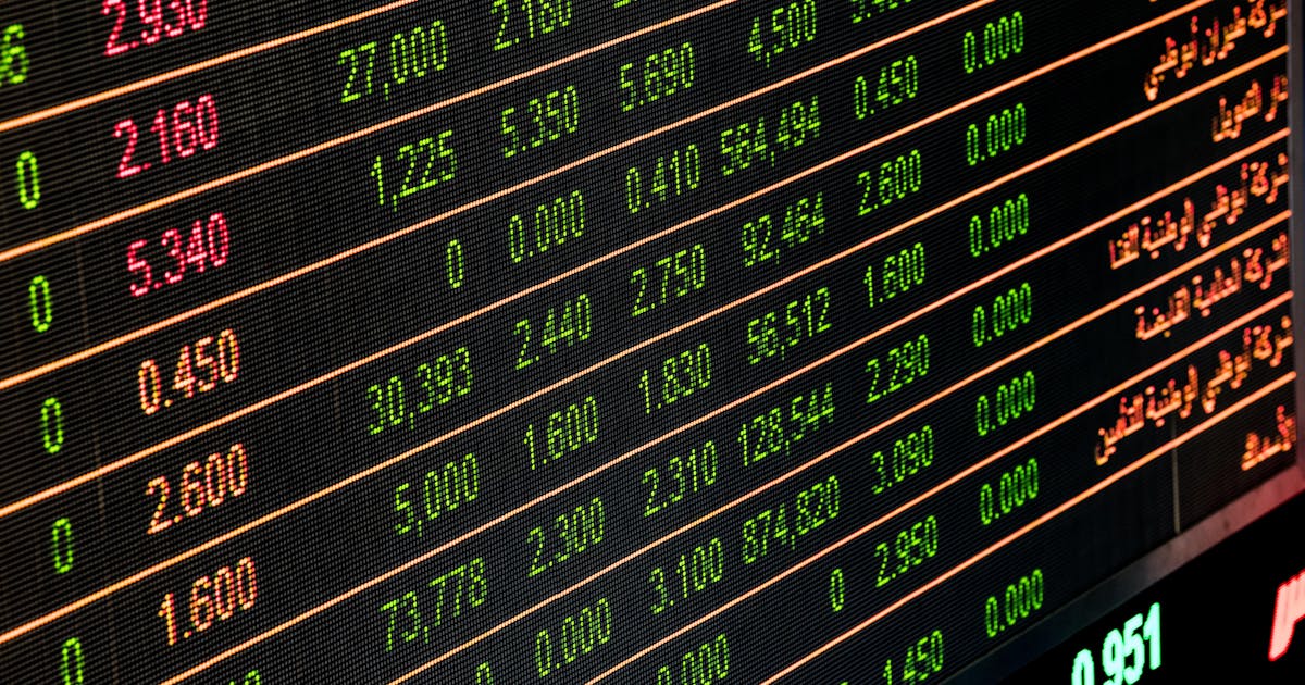 Painel de cotações de ações em verde e vermelho representando bolsa de valores