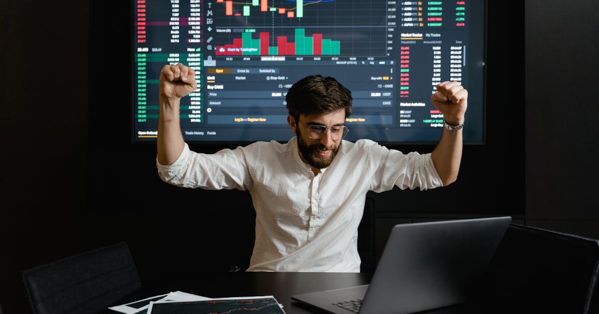 Investidor animado diante de telas com gráficos representando ETFs e fundos de índice