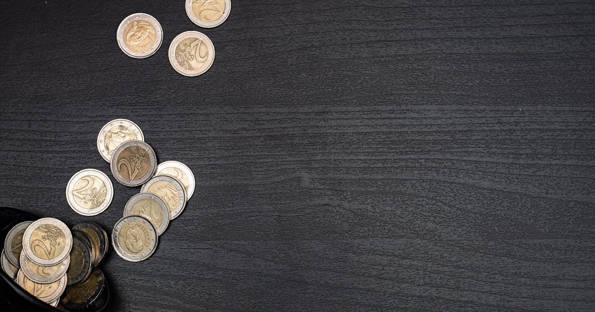 Moedas sobre superfície escura representando taxa CDI e renda fixa