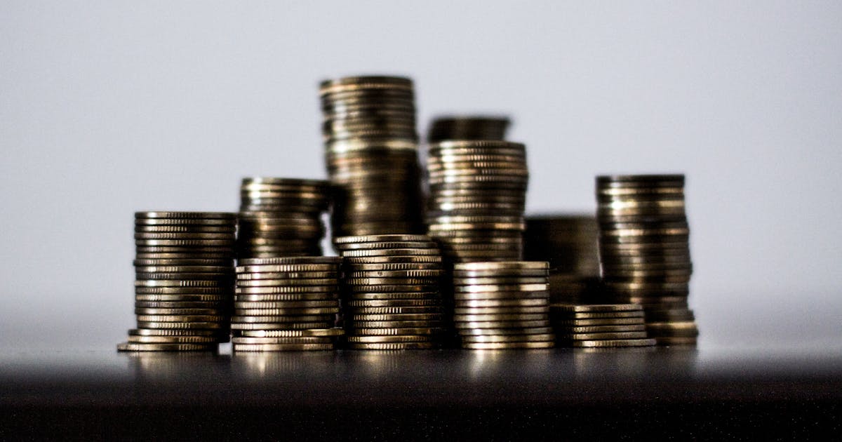 Moedas de ouro empilhadas representando renda fixa CDB e Tesouro Direto