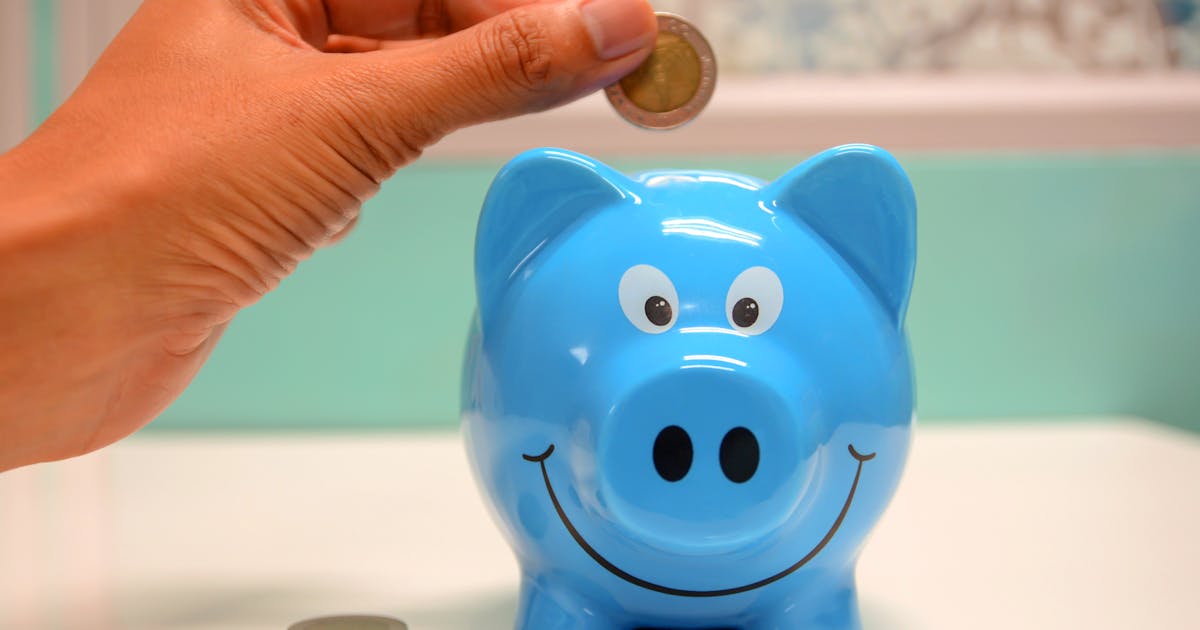 Cofrinho azul com moeda representando renda passiva e independência financeira