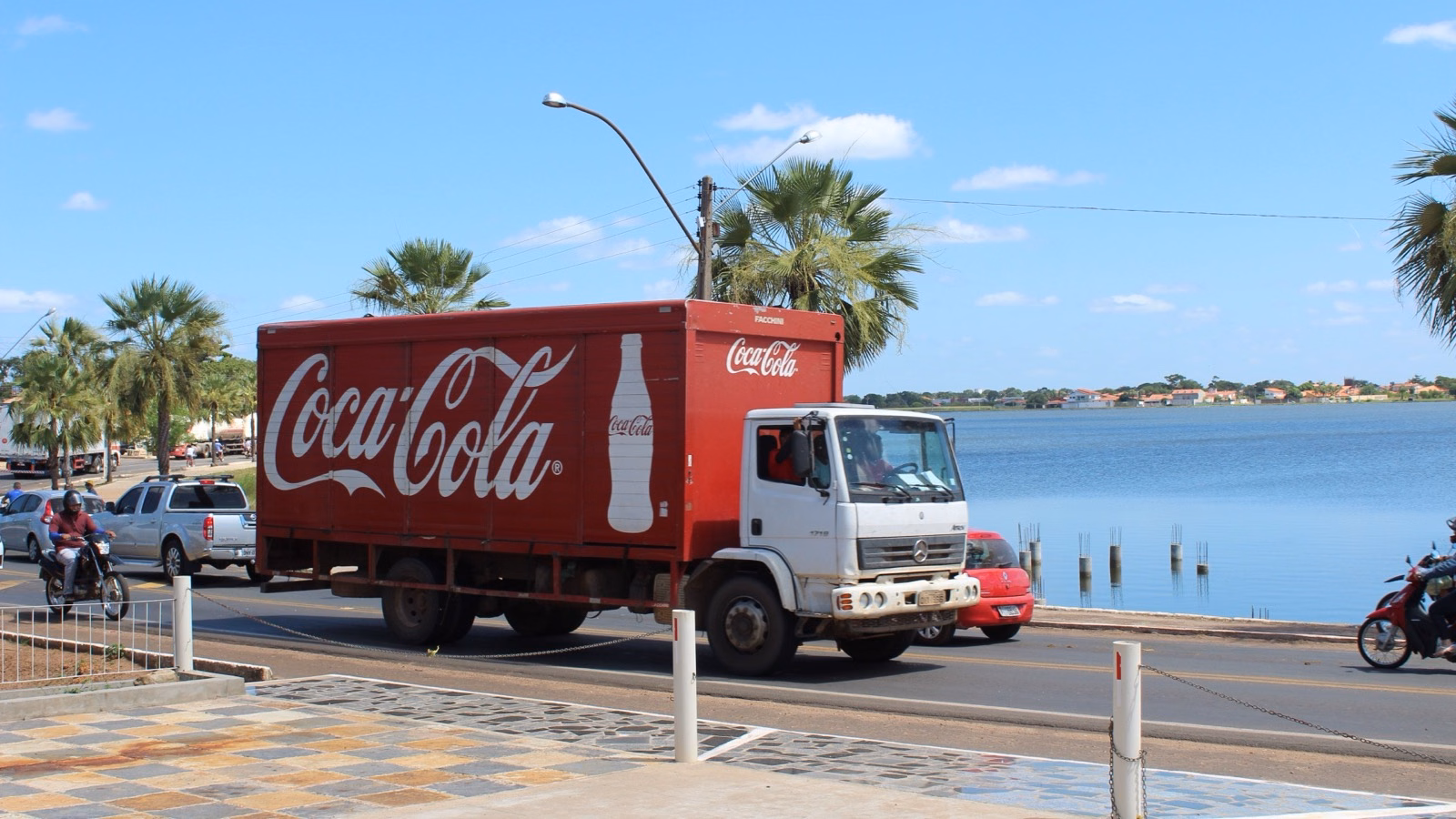 Caminhão vermelho da Coca-Cola em uma rodovia no Brasil