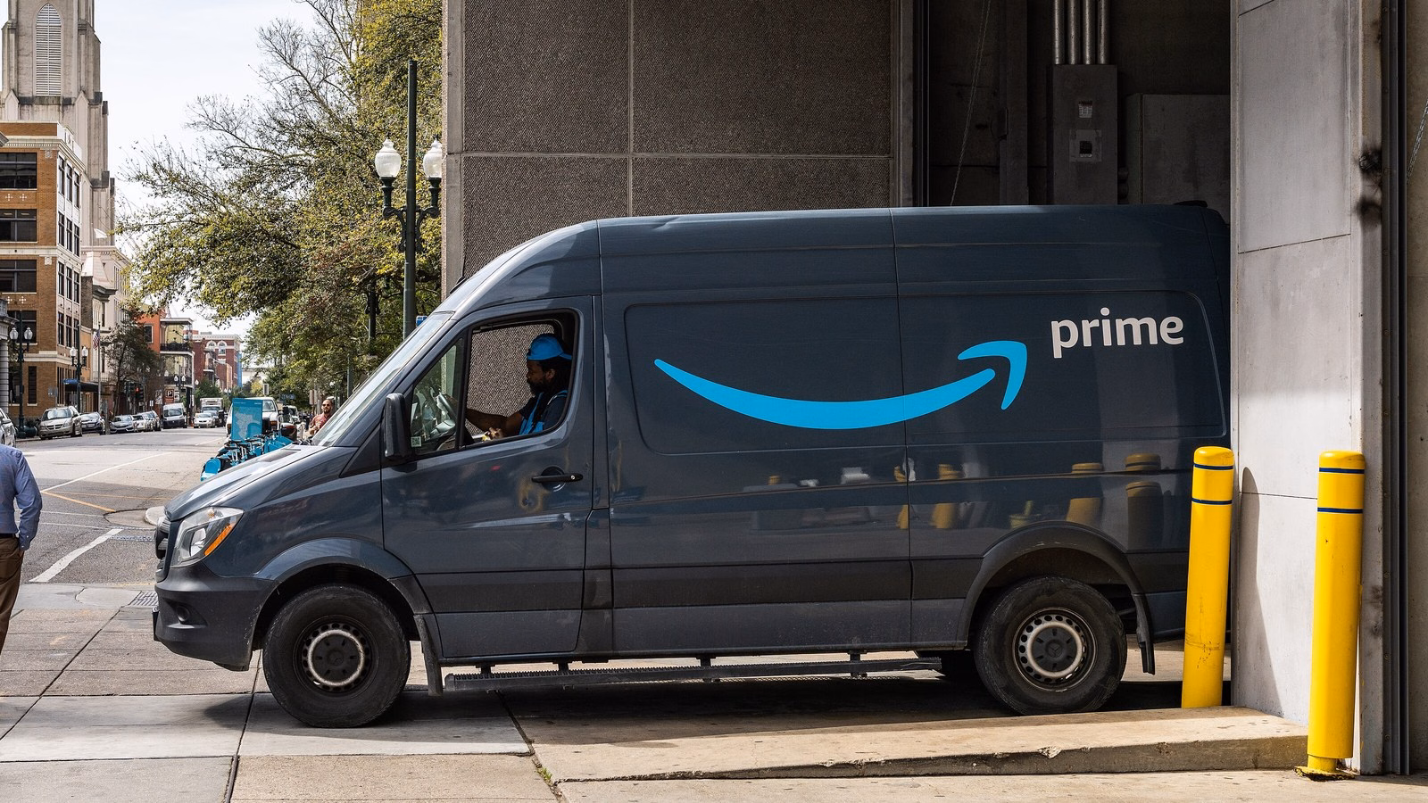 Van de entregas da Amazon com o logo do sorriso e a marca Prime estacionada numa rua de Nova Orleans