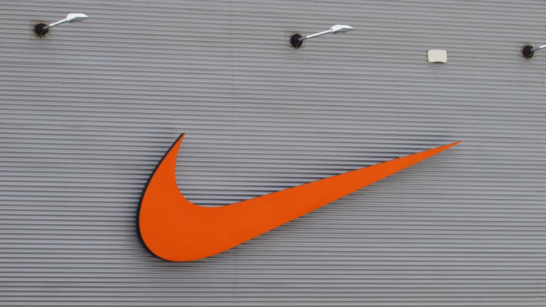 Logo da Nike, o swoosh laranja, na fachada de uma loja