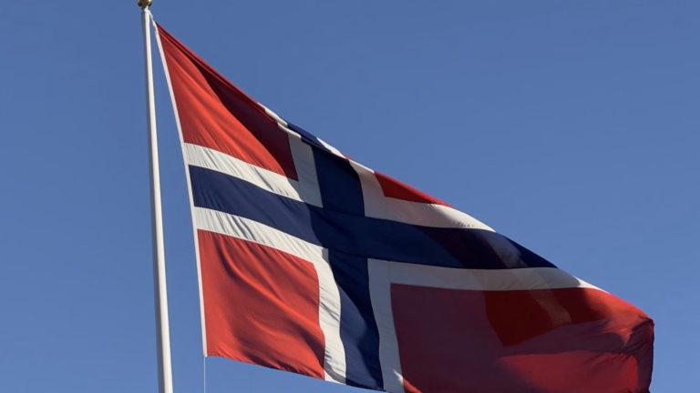 Bandeira da Noruega no mastro em frente ao Palácio Real, em Oslo