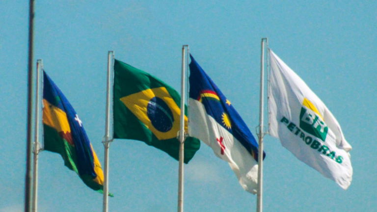 Bandeira da Petrobras com o logo BR hasteada ao lado da bandeira do Brasil