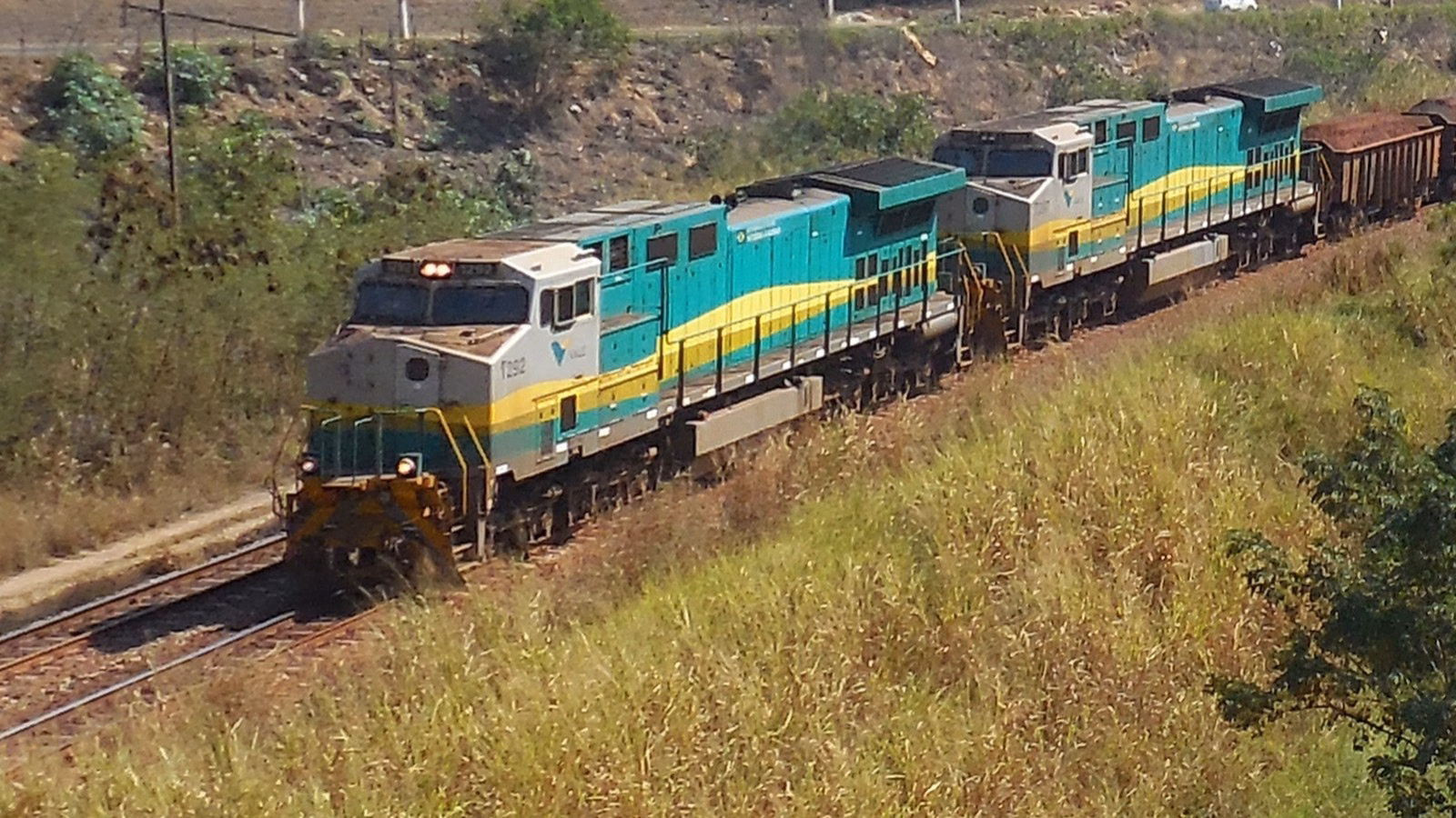 Locomotivas da Vale, com o logotipo na cabine, puxando vagões de minério de ferro na Estrada de Ferro Vitória a Minas